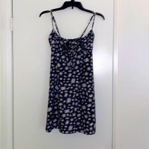 A short, blue, spaghetti-strap, summer dress with white flowers